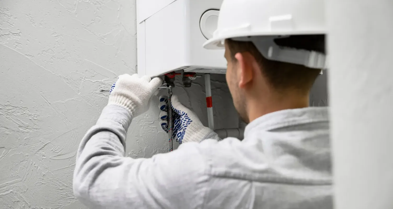 Idraulico durante l'installazione di una nuova caldaia a condensazione.
