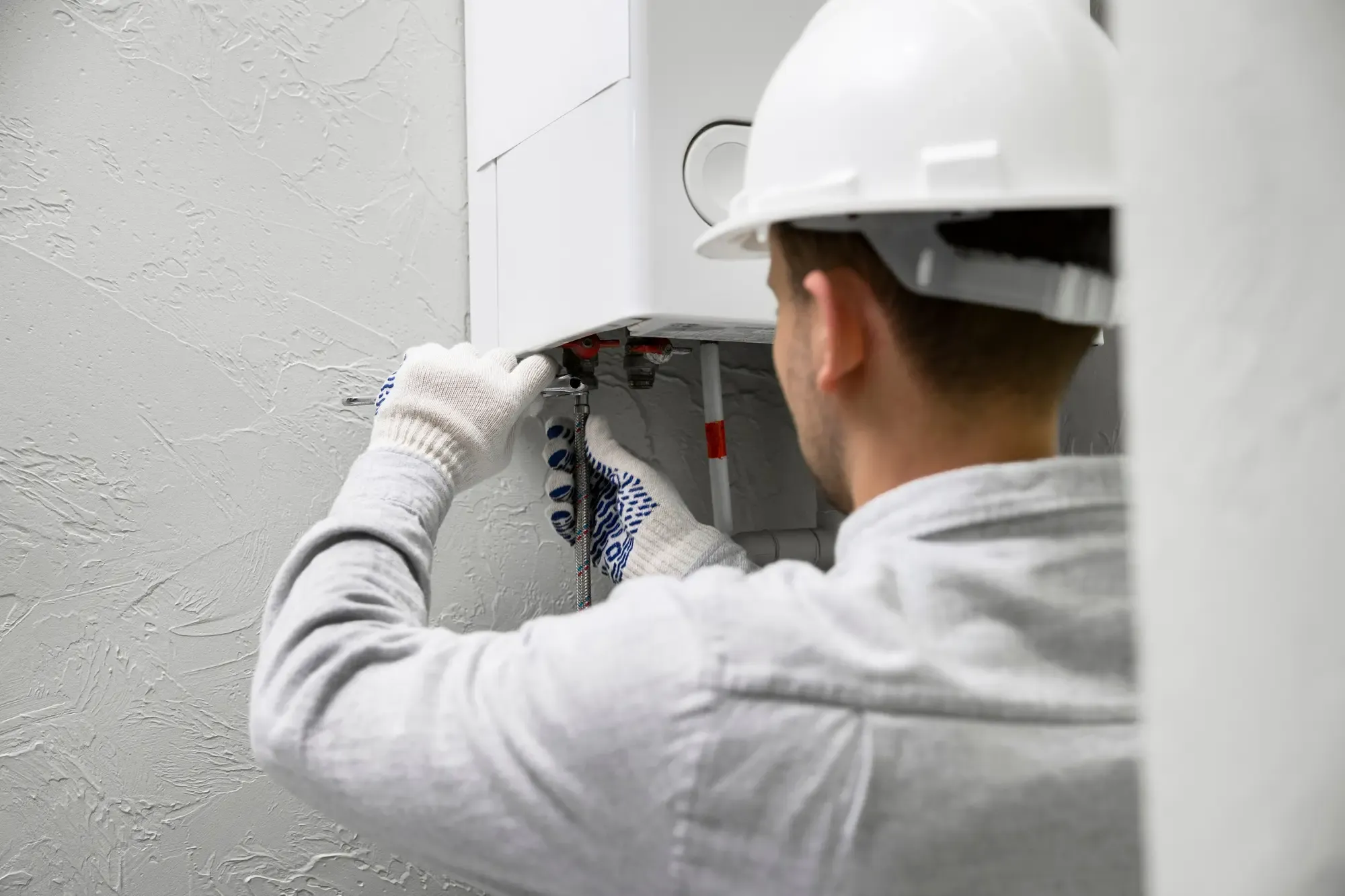 Idraulico durante l'installazione di una nuova caldaia a condensazione.