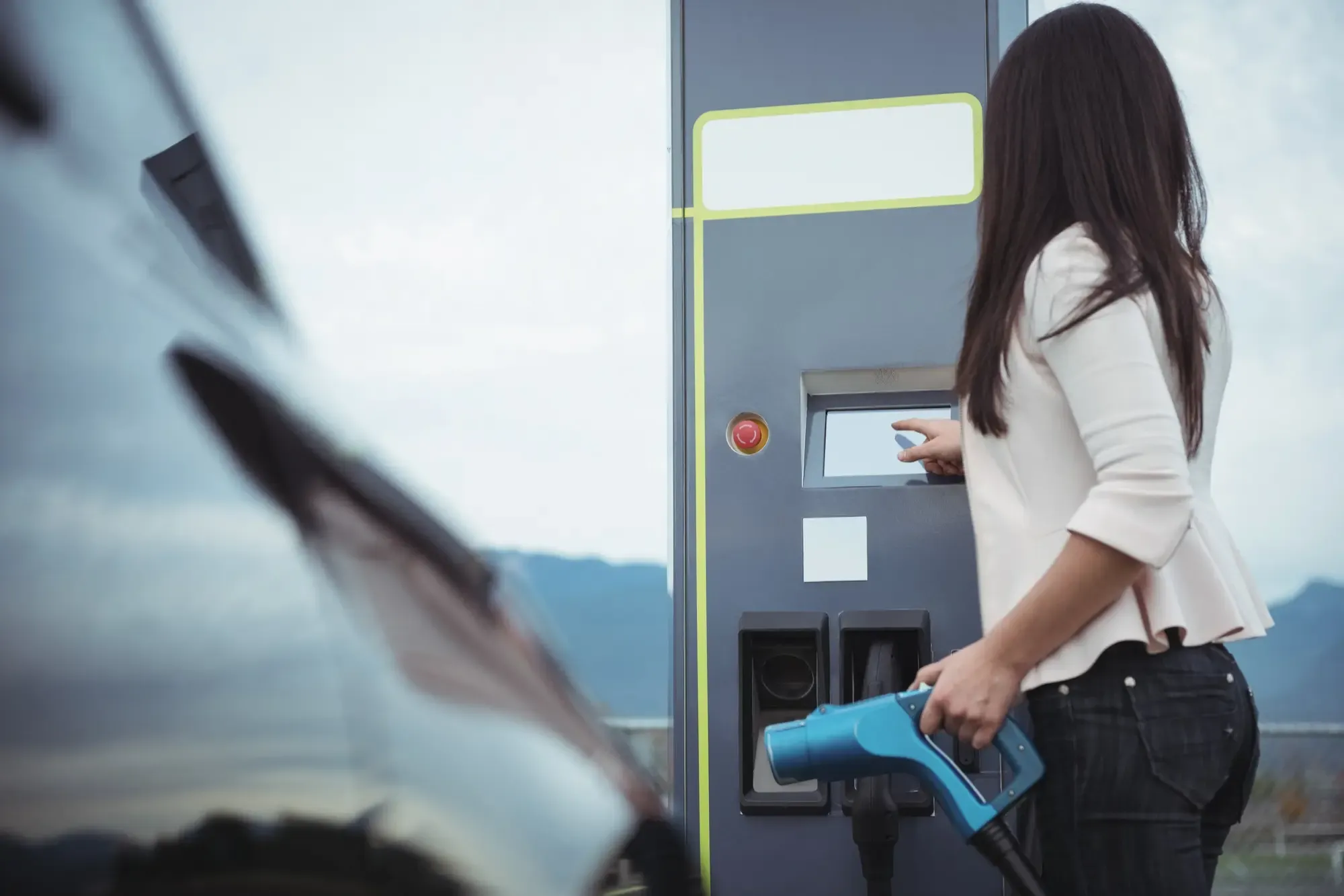 Un'auto elettrica in carica in un garage, collegata a una wallbox.