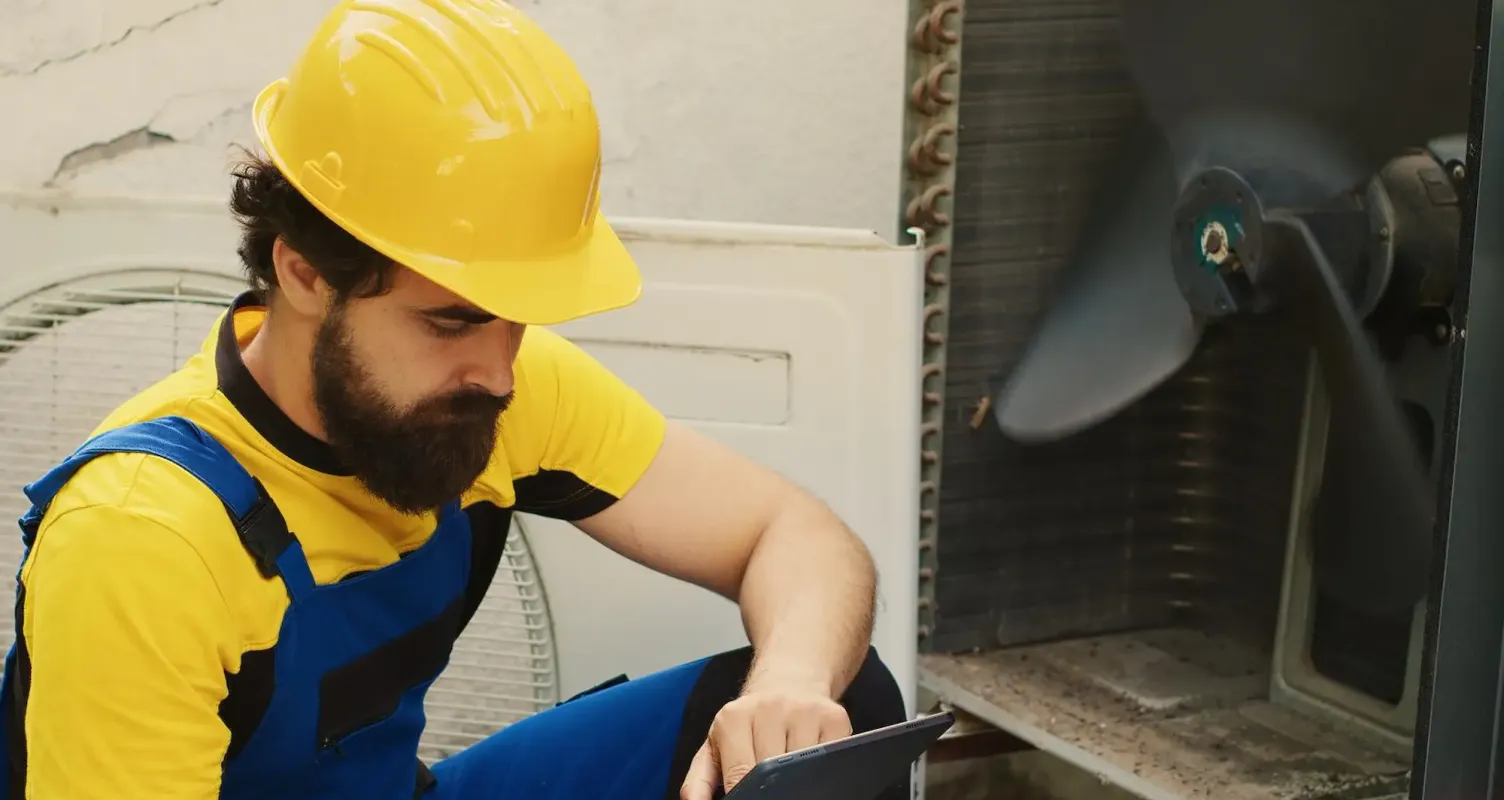 Tecnico che controlla la pressione del circuito di una pompa di calore.