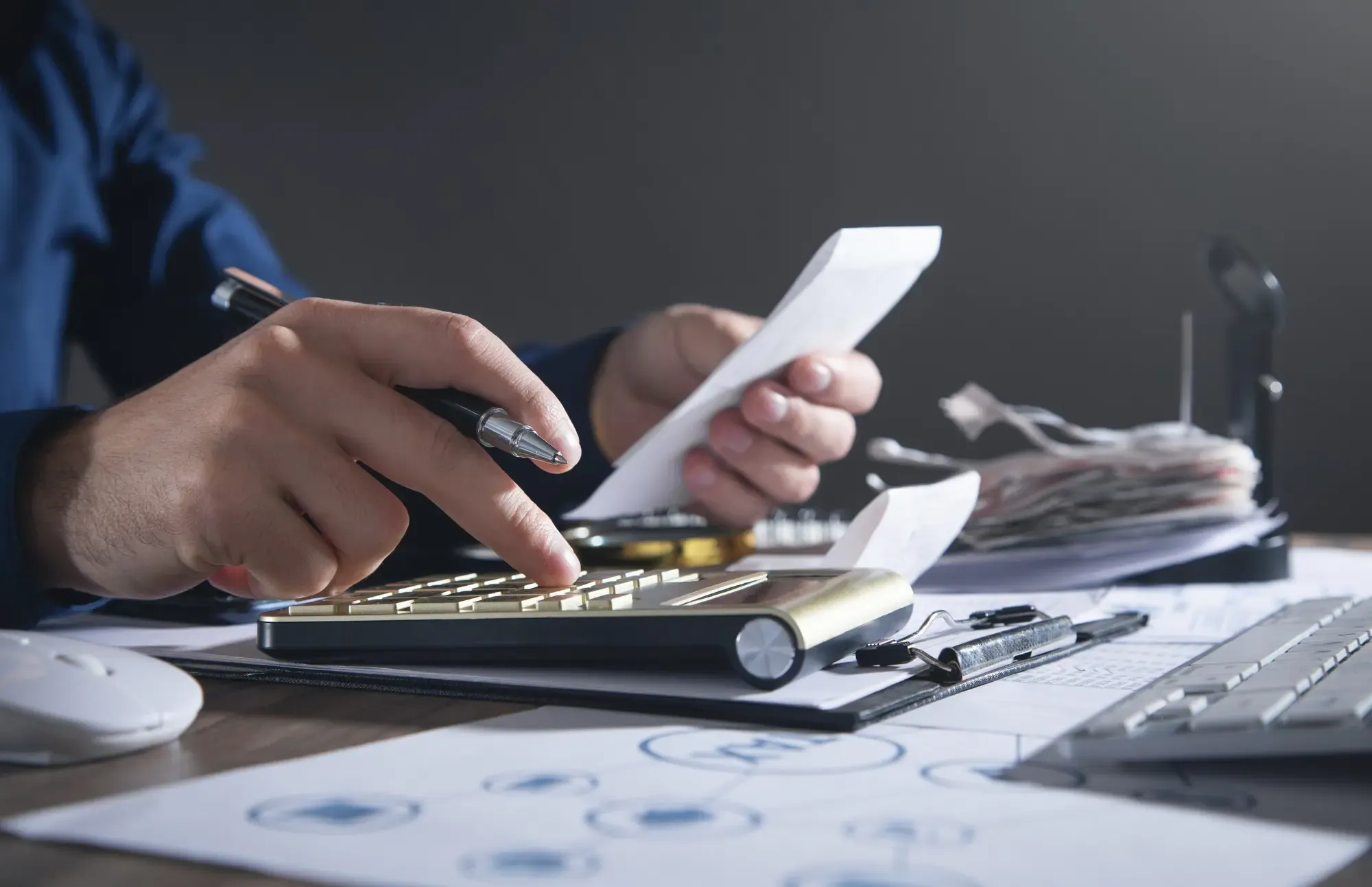 Calcolatrice e penna sopra a documenti, per rappresentare la pianificazione di un finanziamento.