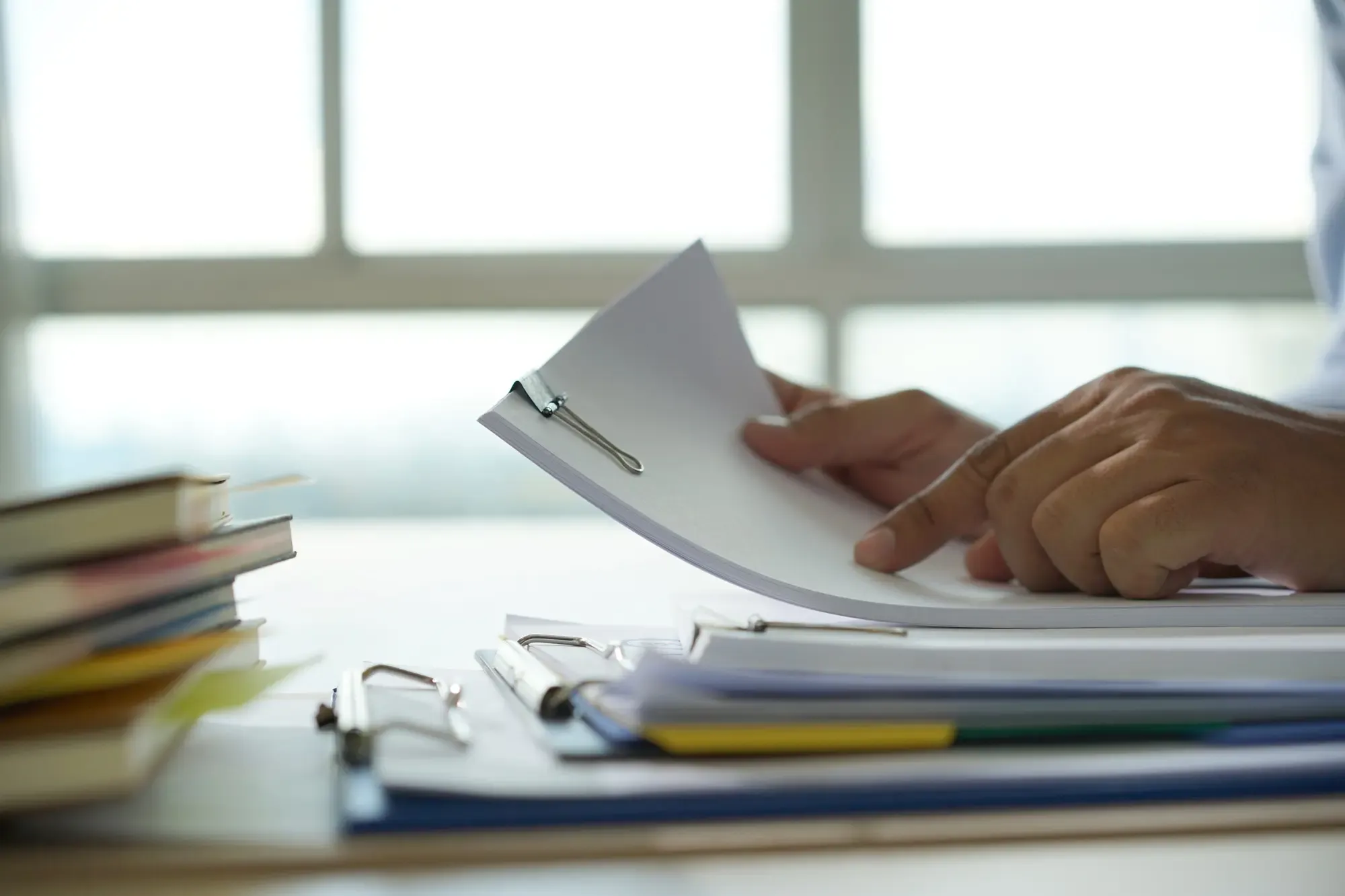 Persona che firma dei documenti, simboleggiando la gestione di pratiche burocratiche per incentivi.