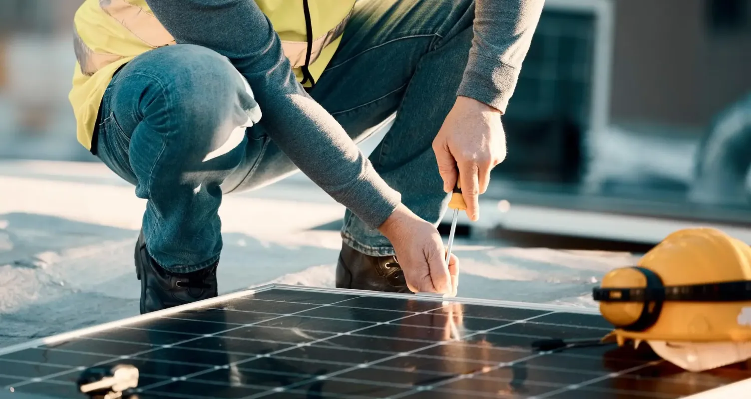 Tecnico specializzato che installa un pannello fotovoltaico sul tetto di un'abitazione.