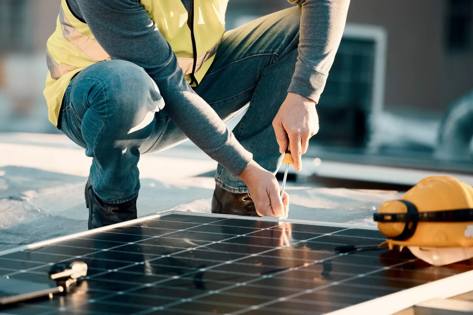 Tecnico specializzato che installa un pannello fotovoltaico sul tetto di un'abitazione.