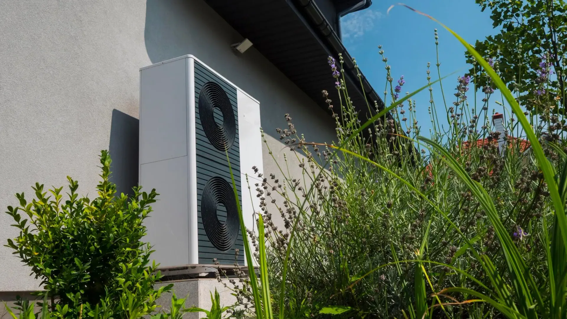 Unità esterna di una pompa di calore installata a fianco di un'abitazione.